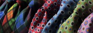 A row of professional neckties in various colors and patterns, symbolizing the diverse roles and departments in a medical device company unified through integrated QMS processes and collaborative compliance.