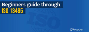 Blue banner for "Beginners guide through ISO 13485," featuring the qmsWrapper logo and a subtle globe graphic in the background.