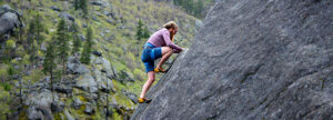 A rock climber on a steep rock face, representing the transition from uncertainty to managed risk through systematic risk assessment, mitigation, and documented proof in a medical device QMS.